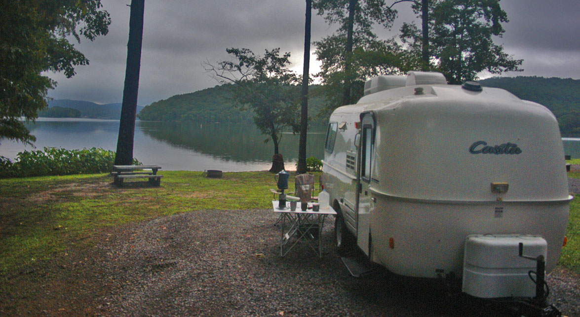 Small travel trailer camped on mountain lake